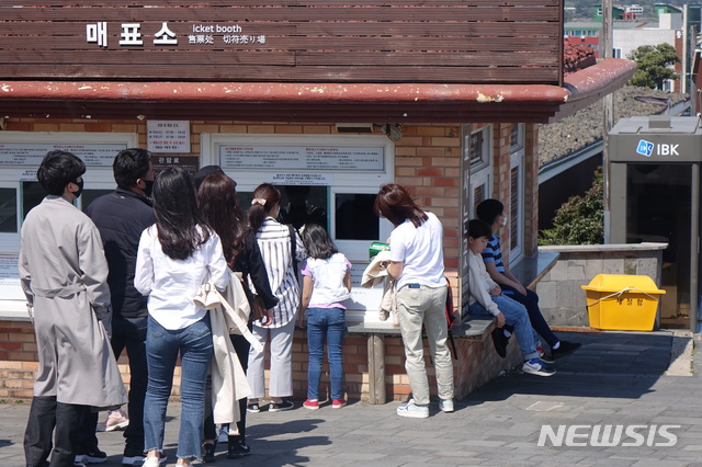 [제주=뉴시스] 양영전 기자 = 황금연휴가 본격적으로 시작된 30일 오전 제주 성산일출봉을 찾은 관광객들이 매표를 위해 줄을 서고 있다. 2020.04.30. 0jeoni@newsis.com
