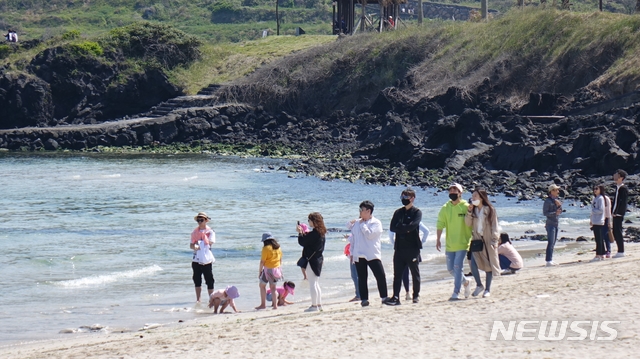 [제주=뉴시스]강경태 기자 = 황금연휴 첫날인 30일 제주시 조천읍 함덕해수욕장에서 관광객들이 바다를 바라보며 걷고 있다. 2020.04.30. ktk2807@newsis.com