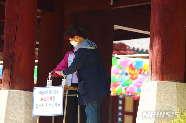 [대구=뉴시스]이지연 기자 = 30일 오후 영천 은해사를 찾은 시민들이 사찰 입구 앞에 비치된 손 소독제를 사용하고 있다. 2020.04.30. ljy@newsis.com 