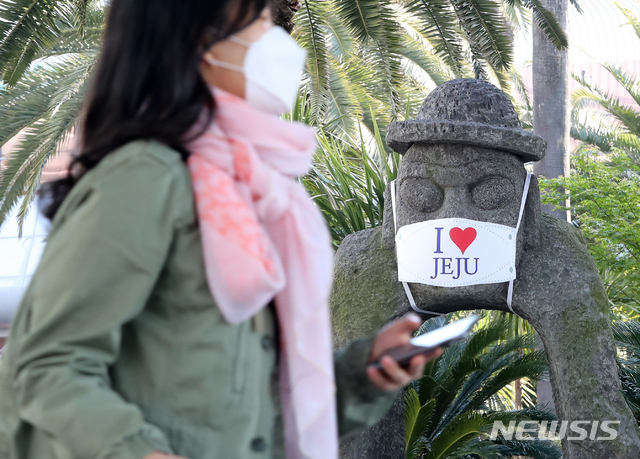 [제주=뉴시스]우장호 기자 = 정부가 고강도 사회적 거리두기를 제한적으로 완화한 가운데 황금연휴가 시작된 지난달 30일 오전 제주국제공항에 서 있는 돌하르방이 신종 코로나바이러스 감염증(코로나19) 예방 마스크를 쓰고 있다. 제주도는 오는 30일부터 시작되는 황금연휴 기간 동안 '코로나19' 주의 환기 차원에서 도내 관광지 40여기의 돌하르방에 마스크를 씌우기로 했다. 2020.04.30. woo1223@newsis.com