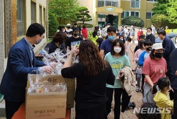 [창원=뉴시스] 경남 창원시 마산회원구 삼계대동이미지아파트대표회가 2일 오전 1단지 관리사무소 앞에서 어린이날 선물로 준비한 과자 꾸러미를 입주민 아동들에게 나눠주고 있다.(사진=이우완 페이스북 제공) 2020.05.02. photo@newsis.com