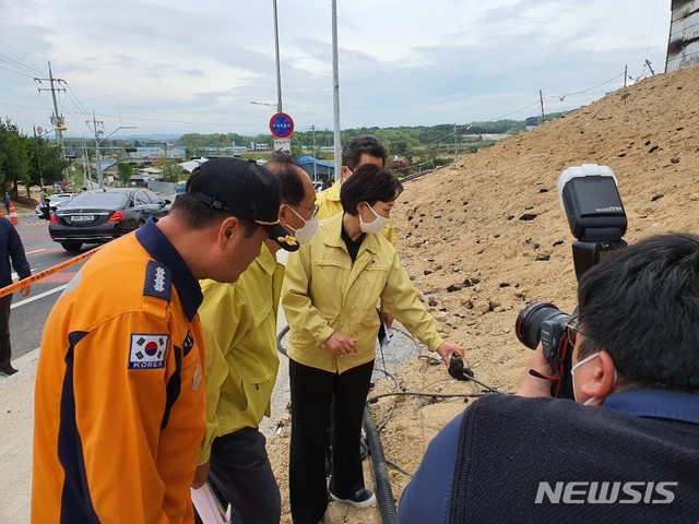 [이천=뉴시스] 김경호 기자= 김현미 국토부장관이 3일 오전 11시10분께 경기 이천 화재참사 현장에서 기자들과의 짧은 인터뷰가 끝난 뒤 차량으로 가다가 걸음을 멈추고 불이 난 건물 외벽에서 날라온 난연재에 대해 소방 관계자에게 묻고 있다. 2020.05.03kgh@newsis.com 