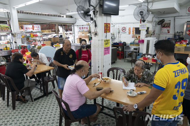[쿠알라룸푸르=AP/뉴시스] 말레이시아 수도 쿠알라룸푸르에 있는 움식점에서 손님들이 아침 식사를 하고 있다. 자료사진. 2025.03.07