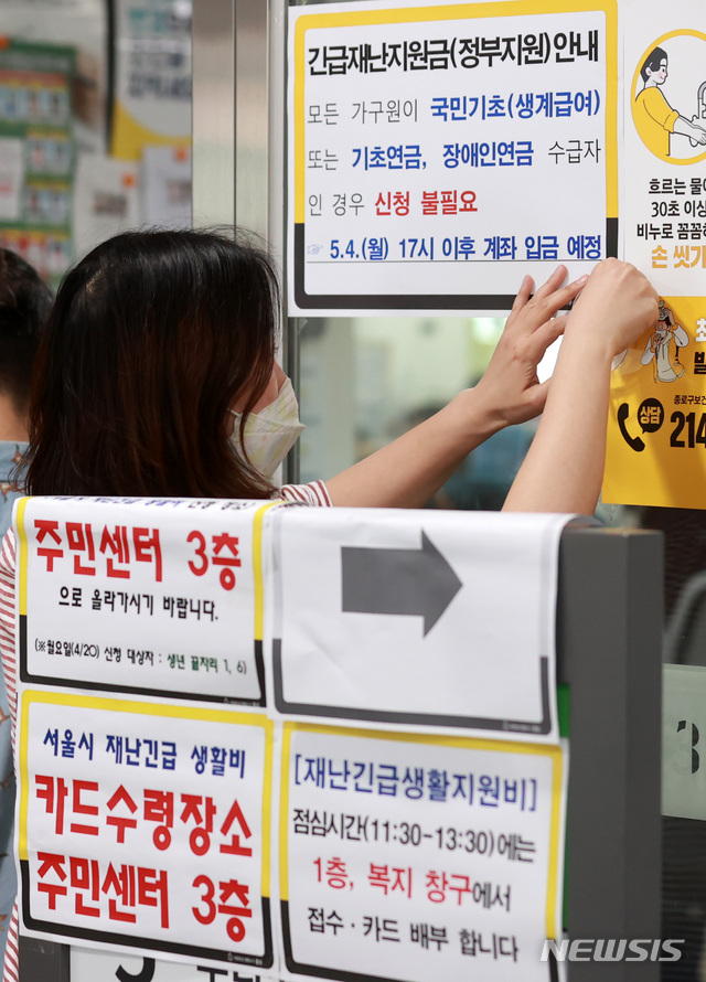 [서울=뉴시스] 이영환 기자 = 지난 4일 서울 종로구 한 주민센터에서 관계자가 안내문을 붙이고 있다. 2020.05.04.&nbsp; 20hwan@newsis.com