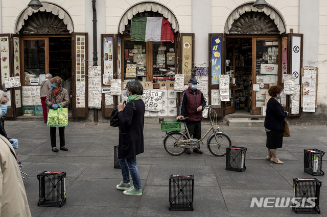 [토리노=AP/뉴시스]4일(현지시간) 이탈리아 북부 토리노의 야외 시장 포르타 팔라조에서 시민들이 마스크를 착용하고 사회적 거리두기를 지키면서 줄 서 있다. 이탈리아는 이날부터 신종 코로나바이러스 감염증(코로나19) 억제를 위해 취한 전국적인 봉쇄 조치를 완화하기 시작했다. 2020.5.4.