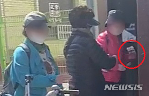 [광주=뉴시스] 변재훈 기자 = 정부가 전통시장 활성화를 위해 발행한 온누리상품권을 현금화하는 불법 거래가 광주에서 벌어지고 있는 듯한 동영상이 5일 입수됐다. 입수 동영상 속에는 지난달 23일 오후 2시께 상품권 판매처인 광주 동구 한 금융기관 앞에서 현금과 온누리상품권으로 보이는 보이는 종이 다발(빨간 원 안)을 교환하는 모습이 담겼다. (사진 = 독자 제공) 2020.05.05.&nbsp; photo@newsis.com