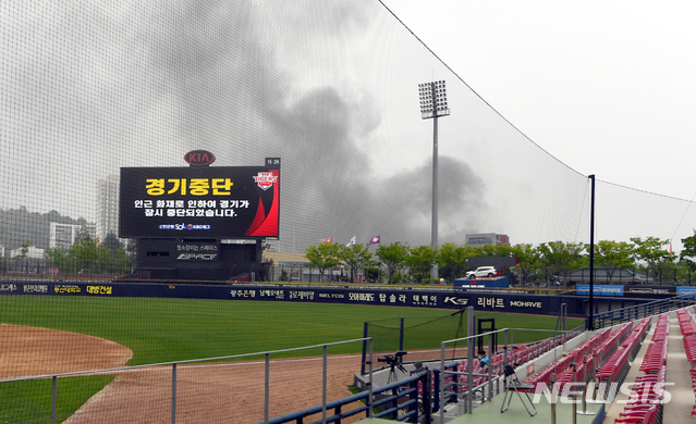 [광주=뉴시스] 류형근 기자 = 5일 오후 광주 북구 광주-기아챔피언스필드에서 2020프로야구 개막전 KIA 타이거즈 대 키움 히어로즈의 경기가 열리고 있는 가운데 4회말 경기장 인근의 화재로 경기가 중단되고 있다. 2020.05.05. hgryu77@newsis.com