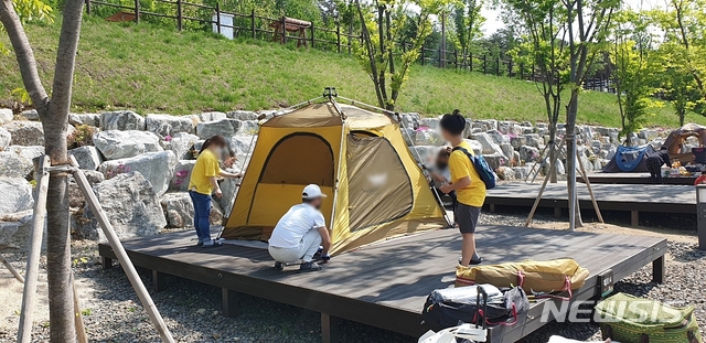 [대구=뉴시스]이지연 기자 = 6일 재개장한 대구 달서구 송현동의 별빛캠핑장을 찾은 한 가족이 텐트를 설치하고 있다. 2020.05.06. ljy@newsis.com 
