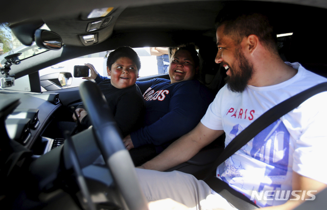 [오그던(미 유타주)=AP/뉴시스] 5일(현지시간) 미국 유타주 오그던에서 5세 소년 애드리언 자마리파(왼쪽)이 엄마의 무릎에 앉아 '람보르기니 우라칸'을 시승하고 있다. 이 소년은 전날 람보르기니를 사기 위해 캘리포니아로 가야 한다면서 부모 차를 직접 몰고 나왔다가 고속도로 순찰대에 적발됐다. 2020.05.06