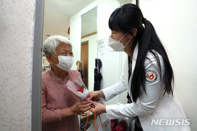 [서울=뉴시스] 이윤청 기자 = 성동구보건소 치매안심센터 관계자가 지난 6일 서울 성동구 한 아파트에서 어르신에게 카네이션과 치매안심키트를 전달하고 있다. <사진과 기사는 관련이 없습니다>2020.05.06. radiohead@newsis.com