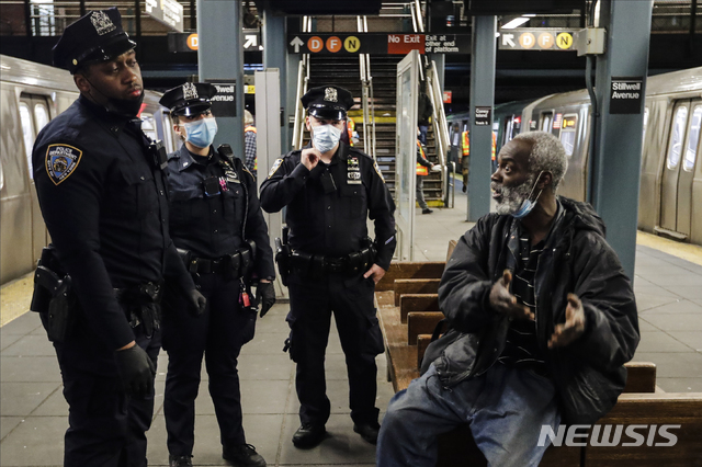 [뉴욕=AP/뉴시스]6일(현지시간) 뉴욕 시내 지하철역에서 경관들이 한 남성에게 역사 일시 폐쇄를 알리고 있다. 2020.05.06.