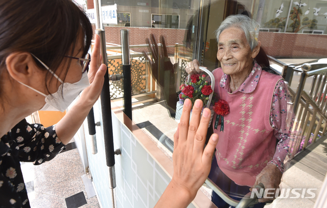 [수원=뉴시스] 김종택 기자 = 어버이날을 하루 앞둔 지난 7일 오후 경기 수원시 장안구 한 요양원에서 가족이 유리창 넘어로 면회하고 있다.&nbsp; 지난 6일부터 '사회적 거리두기'가 '생활 속 거리 두기'로 완화되고 어버이날이 다가오면서 입소자 면회 요청이 늘어났지만 요양원측은 코로나19 예방을 위해 기존 지침대로 직접 면회를 제한 하기로 했다. 2020.05.07.&nbsp; semail3778@naver.com