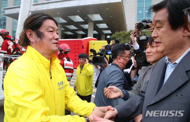 [서울=뉴시스] 장세영 기자 = 국회의원회관 현관 캐노피에 올라가 형제복지원 사건 등에 대한 과거사법 개정안 통과를 요구하며 시위를 하고 있는 최승우 씨가 7일 서울 여의도 국회에서 여야가 전격 합의하면서 국회 농성을 중단하고 캐노피에서 내려와 김무성 미래통합당 의원과 인사를 나누고 있다. 2020.05.07.&nbsp; photothink@newsis.com