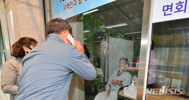 [광주=뉴시스] 변재훈 기자 = 어버이날인 지난 5월8일 광주 광산구 우산동 한 요양병원에서 입원환자와 가족들이 비접촉 면회를 하고 있다. 병원 측은 코로나19 확산 방지를 위해 건물 외벽 유리창을 사이에 두고 무선 전화로 대화할 수 있는 비접촉 면회실을 마련했다. 2020.05.08.  wisdom21@newsis.com