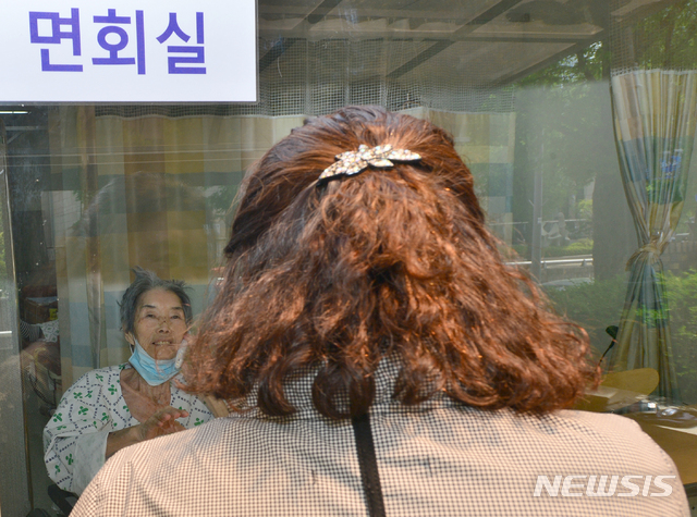 [광주=뉴시스] 변재훈 기자 = 어버이날인 8일 광주 광산구 우산동 한 요양병원에서 입원환자와 가족들이 비접촉 면회를 하고 있다. 병원 측은 코로나19 확산 방지를 위해 건물 외벽 유리창을 사이에 두고 무선 전화로 대화할 수 있는 비접촉 면회실을 마련했다. 2020.05.08.wisdom21@newsis.com