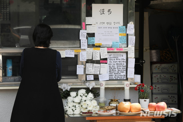 [서울=뉴시스] 박민석 기자 = 서울 강북구의 한 아파트 입주민이 11일 이 아파트 경비실 앞에 마련된 추모 공간을 살펴보고 있다. 지난달 21일과 27일, 이 아파트 주차장에서 발생한 주차 문제로 인해 입주민에게 폭행을 당한 경비원 최모씨는 지난 10일 자신의 자택에서 숨진 채 발견됐다. 2020.05.11. mspark@newsis.com