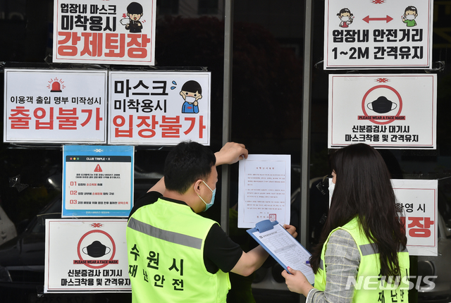 [수원= 뉴시스] 김종택기자 = 이태원 클럽 집단 감염 영향으로 신종 코로나바이러스 감염증(코로나19) 확산이 우려되는 가운데 11일 오후 경기 수원시 팔달구 한 클럽에서 수원시청 관계자들이 코로나19 확산 방지를 위한 집합금지명령서를 부착하고 있다. 2020.05.11.semail3778@naver.com