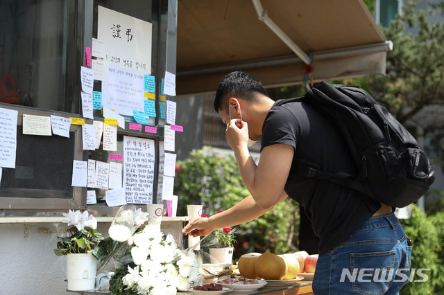 [서울=뉴시스] 박민석 기자 = 한 시민이 지난 5월11일 서울 강북구의 한 아파트 경비실 앞에 마련된 경비원의 추모 공간에서 분향하고 있다. 2020.05.11. mspark@newsis.com