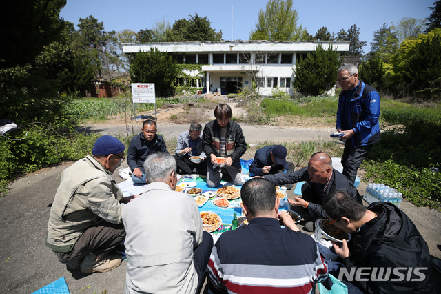 [광주=뉴시스] 조수정 기자 = 5·18 광주민주화운동 고문피해자 곽희성, 김중현, 박갑수, 박성열, 박시영, 서정열, 양동남, 이성전, 허춘섭 씨가 5·18 40년을 앞두고 24일 오후 트라우마 치유 과정 중 하나로 고문을 겪은 장소인 광주 서구 상무대로 505보안부대 옛터 앞에 둘러앉아 자장면으로 점심 식사를 하고 있다. "우리가 여기 자장면을 먹기위해 앉아있을 수 있게 될 지 누가 알았겠어"라고 말한다. "죽어서 나오지 못 할 수도 있었다고 생각했다"고 말하는 이들은 상무대에서 505보안대대로 끌려다니며 국가의 폭력을 겪었다. "끌려올 때 안대를 씌우지만 안대가 흘러내리며 공간을 조금씩 볼 수 있었다"고 말한다. 40년간 트라우마를 겪고 있지만 이 공간에 들어가는 날은 더욱 힘들다. 이들은 고통의 공간을 직접 마주하며 사진으로 트라우마를 치유한다. 5·18을 기억하고 기록하며 의미있는 현재를 살아가기 위한 과정이다. 2020.04.24. chocrystal@newsis.com