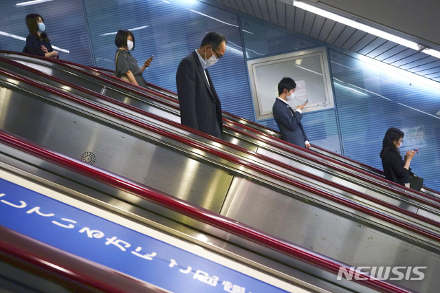 [도쿄=AP/뉴시스]지난 11일 일본 도쿄의 한 지하철역 에스컬레이터에 신종 코로나바이러스 감염증(코로나19)예방을 위해 마스크를 쓴 시민들이 서 있다. 2020.05.12.