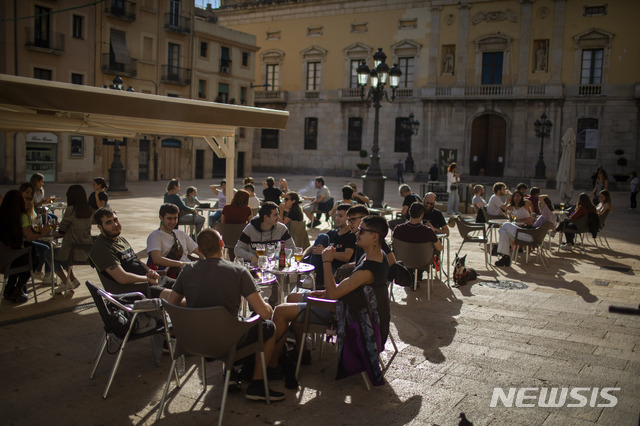 [타라고나(스페인)=AP/뉴시스] 5월11일(현지시간) 스페인 타라고나의 한 야외 바에 모인 시민들이 술을 마시고 있다. 신종 코로나바이러스 감염증(코로나19) 봉쇄가 점진적으로 완화되면서 약 4700만 스페인 인구 중 절반은 외출과 사교활동을 시작하고 소규모 매장에서 쇼핑을 즐기며 야외 좌석이 있는 식당 등에서 식사나 커피를 즐기고 있다.&nbsp; 2020.05.12.