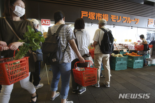 [요코하마=AP/뉴시스]12일 일본 도쿄 인근 요코하마의 한 청과물 상가에서 신종 코로나바이러스 감염증(코로나19) 확산을 막기 위해 마스크를 쓴 시민들이 쇼핑하고 있다. 스가 요시히데 일본 관방장관은 전국에 확대한 코로나19 관련 긴급사태 선언을 14일 일부라도 해제할 방침이라고 밝혔다. 2020.05.12.