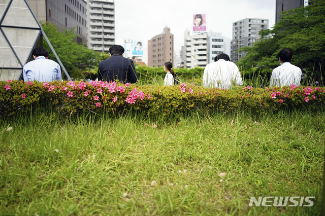 [도쿄=AP/뉴시스] 일본 도쿄 시내애 있는 공원에서 직장인들이 일정한 간격을 두고 앉아 점심 도시락을 먹고 있다. 자료사진. 2025.08.06