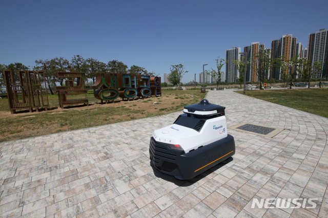 [서울=뉴시스]자동차 부품 전문기업 ㈜만도의 자율주행 순찰 로봇 '골리(Goalie)'가 배곧생명공원에서 기념 촬영을 하고 있다. 2020.05.13 (사진 = 만도 제공) photo@newsis.com