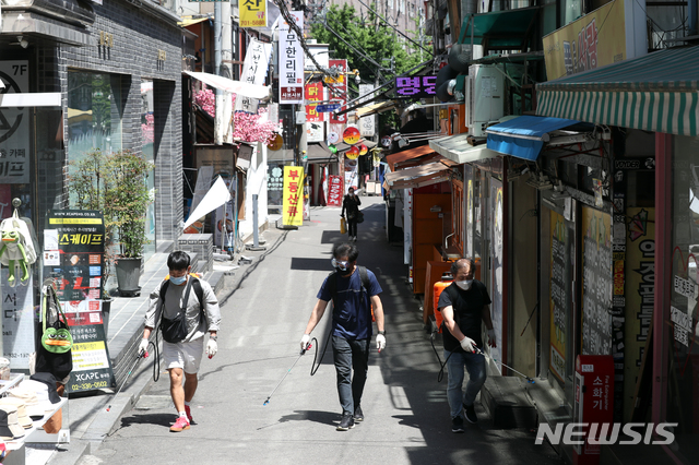 [서울=뉴시스] 이윤청 기자 = 이태원 클럽에 이어 홍대 주점을 방문한 사람들 중에서도 신종 코로나바이러스 감염증(코로나19) 확진자가 발생한 13일 서울 마포구 홍대거리에서 홍대소상공인번영회 관계자들이 일대를 방역하고 있다. 2020.05.13. radiohead@newsis.com