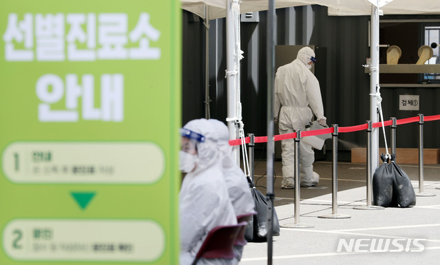 [서울=뉴시스]홍효식 기자 = 이태원 클럽발 집단감염으로 검사 수요가 폭증하고 있는 13일 서울 용산구 한남동 주민센터 옆 공영주차장에 설치된 워크스루 방식 선별진료소에서 관계자들이 방역을 하고 있다. 2020.05.13.&nbsp; yesphoto@newsis.com