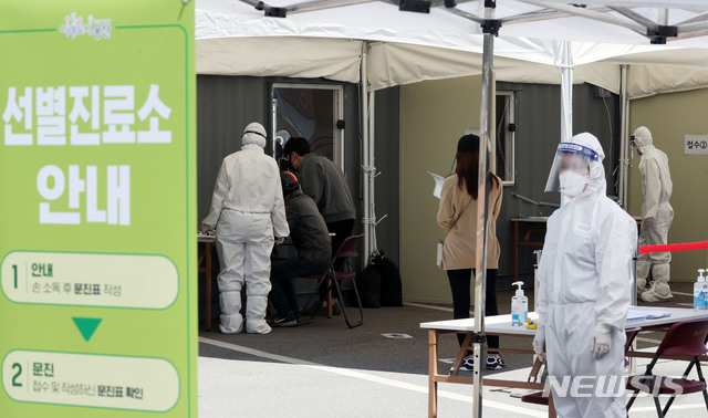 [서울=뉴시스]홍효식 기자 = 이태원 클럽발 집단감염으로 검사 수요가 폭증하고 있는 13일 서울 용산구 한남동 주민센터 옆 공영주차장에 설치된 워크스루 방식 선별진료소에서 관계자들이 업무를 보고 있다. 2020.05.13.&nbsp;&nbsp; yesphoto@newsis.com
