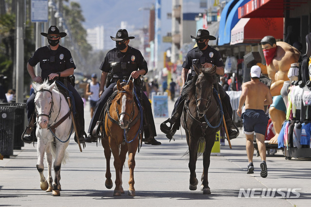 [로스앤젤레스=AP/뉴시스]13일(현지시간) 미 캘리포니아주 로스앤젤레스(LA)의 베니스비치에서 기마 경찰이 순찰하고 있다. 2020.05.14.