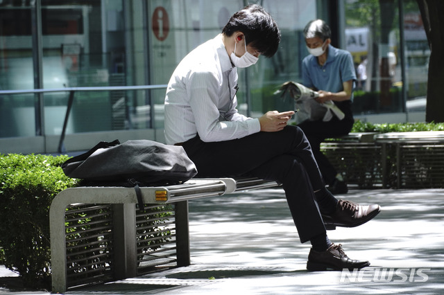 [도쿄=AP/뉴시스]지난 14일 일본 도쿄에서 신종 코로나바이러스 감염증(코로나19) 예방을 위해 마스크를 착용한 시민이 벤치에 앉아 휴식을 취하고 있다. 2020.05.15.