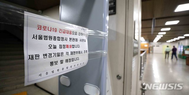 [서울=뉴시스]김선웅 기자 = 15일 서울 서초구 서울법원종합청사(고법·중앙지법)에 법정 폐쇄 안내문이 붙어있다. 법원은 서울구치소 직원의 코로나19 확진 등으로 인한 사전 예방적 조치로 금일 청사 동관 및 서관 법정을 폐쇄하고 진행 예정이던 재판은 모두 연기한다고 밝혔다. 다만 구속 전 피의자 심문 등 급박한사건의 경우 별관에 특별법정을 마련해 진행하며 또한 청사 내부를 방역, 소독할 예정이다. 2020.05.15. mangusta@newsis.com
