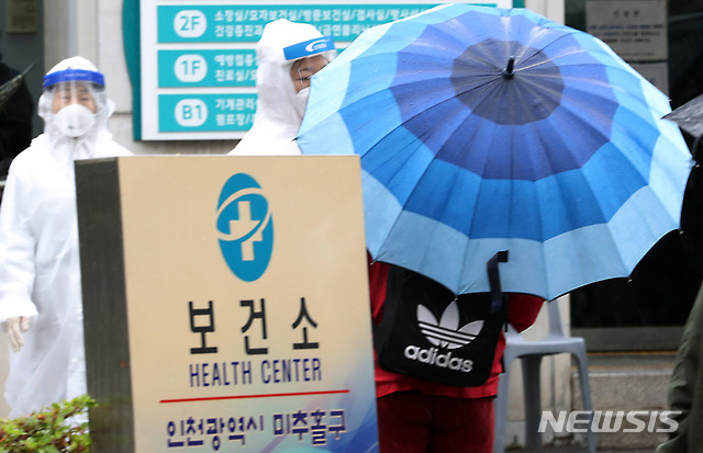 [인천=뉴시스] 이종철 기자 = 비 내리는 15일 오전 인천시 미추홀구 보건소 선별진료소에서 의료진들이 신종 코로나바이러스 감염증(코로나19) 검사를 하기 위해 방문한 시민을 안내하고 있다. 2020.05.15. jc4321@newsis.com