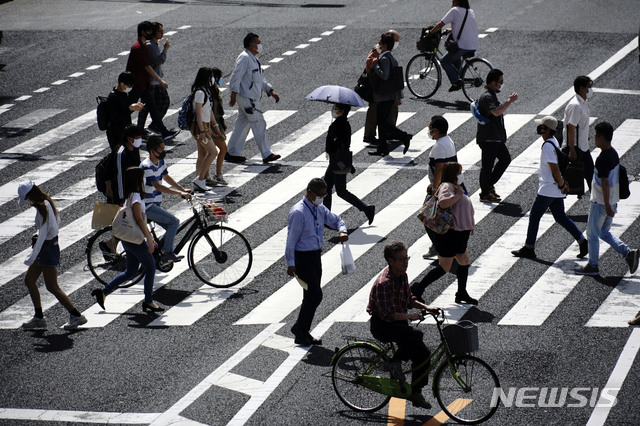 [도쿄=AP/뉴시스] 지난 15일 일본 도쿄의 한 횡단보도를 마스크를 쓴 시민들이 건너고 있다. 일본 정부는 지난 14일 전국 47개 지역 가운데 39개 지역에서 신종 코로나바이러스 감염증(코로나19) 예방을 위해 발령했던 긴급사태 선언을 해제했다. 
