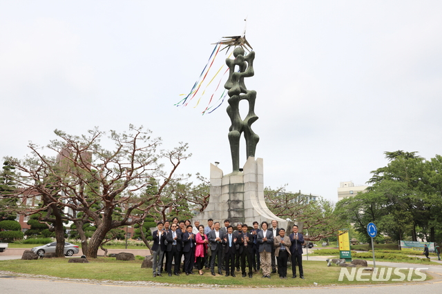 [광주=뉴시스] 송창헌 기자 = 전남대의 상징인 용봉탑의 최상단에 자리한 봉황이 42만에 복원·교체됐다고 대학측디 17일 밝혔다. 정병석 총장과 교직원, 학생들이 기념사진을 찍고 있다. (사진=전남대 제공) 2020.05.17photo@newsis.com