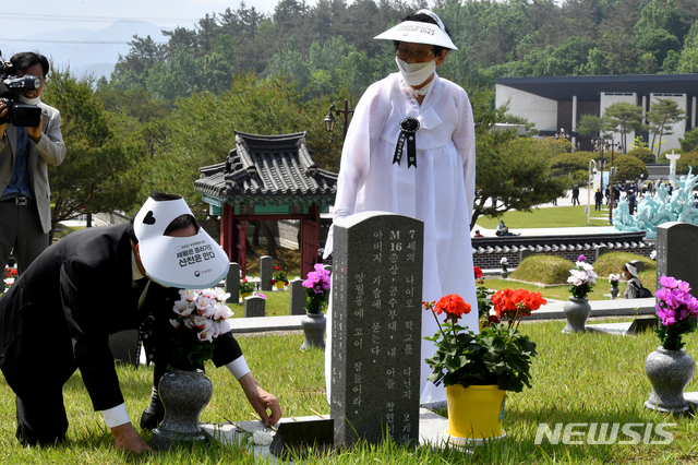[광주=뉴시스] 신대희 기자 = 5·18광주민주화운동 40주년 기념식을 하루 앞둔 17일 광주 북구 운정동 국립5·18민주묘지 행방불명자 묘역에서 이창현 군(1980년 5월19일 실종, 당시 양동초 1학년)의 부모가 묏등 없는 묘비를 만지고 있다. 2020.05.17.&nbsp;&nbsp; sdhdream@newsis.com