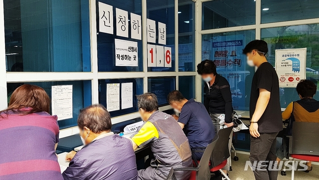 [대구=뉴시스]이지연 기자 = 18일 오전 대구 서구 상중이동복지센터에 긴급재난지원금을 신청하러 온 주민들이 신청서를 작성하고 있다. 2020. 05.18. ljy@newsis.com