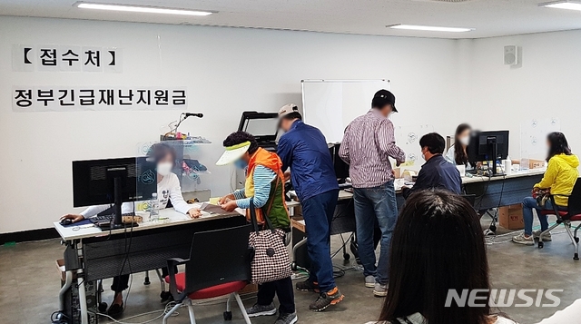 [대구=뉴시스]이지연 기자 = 18일 오전 대구 서구 상중이동복지센터 2층에 마련된 사무실에서 주민들이 긴급재난지원금을 신청하고 있다. 2020.05.18. ljy@newsis.com 
