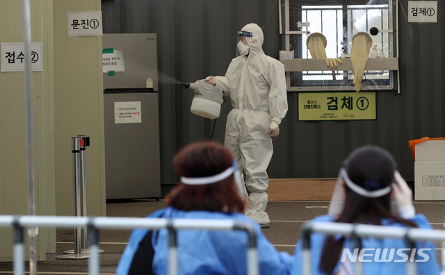 [서울=뉴시스] 이영환 기자 = 18일 오후 서울 용산구 한남동 공영주차장에 마련된 코로나19 선별진료소에서 관계자가 방역잡업을 하고 있다. 2020.05.18. 20hwan@newsis.com