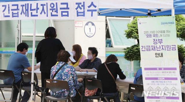 [서울=뉴시스] 박미소 기자 = 신종 코로나바이러스 감염증(코로나19) 대응을 위한 긴급재난지원금 현장 신청 첫 날인 18일 오후 서울 성동구 금호2.3가동주민센터에서 주민들이 신청서 접수를 하고 있다. 2020.05.18. misocamera@newsis.com