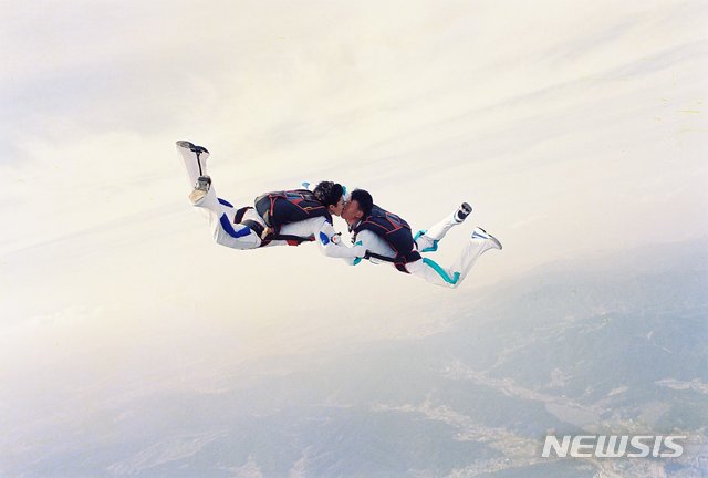 [서울=뉴시스] 1999년에 있었던 고공강하 결혼식에서 특수전사령부 김임수·박철순 원사(당시 계급 중사)가 강하를 하며 포즈를 취하고 있다. 2020.05.20. (사진=육군 제공)
