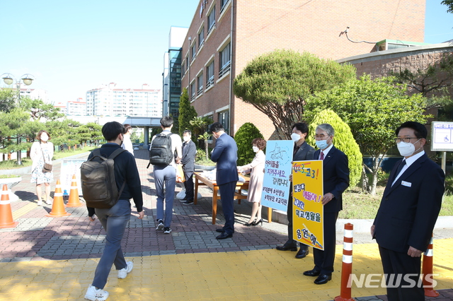 [창원=뉴시스] 홍정명 기자= 고교 3학년 등교수업 첫날인 20일 오전 창원용호고등학교 정문에서 박종훈(오른쪽 두 번째) 경남교육감이 손피켓을 들고 학생들을 응원하고 있다.(사진=경남교육청 제공) 2020.05.20. photo@newsis.com