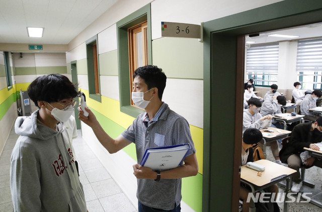 [서울=뉴시스] 박민석 기자 = 고등학교 3학년의 등교 수업 첫날인 20일 오전 서울 종로구 대신고등학교에서 고등학교 3학년 담임선생님이 교실에 입장하는 학생의 발열 상태를 점검하고 있다. 2020.05.20. mspark@newsis.com