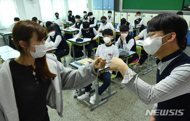 [수원= 뉴시스] 김종택기자 = 고등학교 3학년 등교가 시작된 20일 오전 경기 수원시 팔달구 수원고등학교에서 교사가 학생과 반갑게 주먹인사를 하고 있다. 2020.05.20.semail3778@naver.com