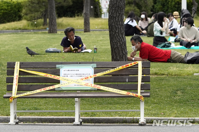 [요코하마=AP/뉴시스]지난 15일 일본 도쿄 인근 가나가와현 요코하마의 한 공원에서 신종 코로나바이러스 감염증(코로나19) 예방을 위해 마스크를 쓴 시민들이 휴식을 취하고 있다. 2020.05.20. 