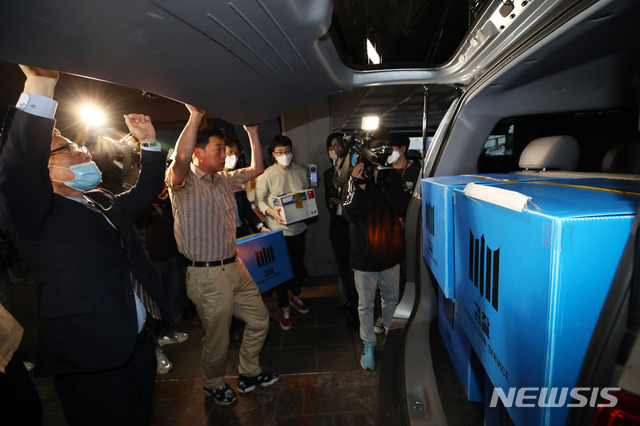 [서울=뉴시스] 고범준 기자 = 검찰 수사관들이 21일 오전 서울 마포구 정의기억연대(정의연)사무실에서 부실 회계 의혹 등을 받는 정의연에 대한 압수수색을 마치고 압수품을 차량에 싣고 있다. 2020.05.21.&nbsp; bjko@newsis.com