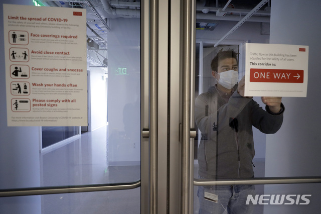 [보스턴=AP/뉴시스] 지난달 21일 미국 보스턴 대학교의 운영위원장이 교내 출입문에 안내문을 부착하고 있다. 2020.7.8.