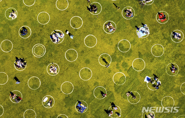 [샌프란시스코=AP/뉴시스] 21일(현지시간) 미국 샌프란시스코 돌로레스 파크를 찾은 시민들이 코로나19 전파 예방을 위해 그려진 흰색 원 안에 자리를 잡고 휴식을 취하고 있다. 